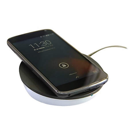 Ein schwarzes Smartphone liegt zum induktiven Laden auf einer runden, weiß-schwarzen Ladestation.