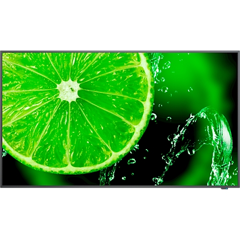 Gros plan sur une tranche de citron vert avec des éclaboussures d'eau sur fond vert.