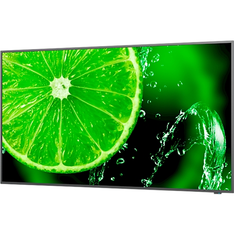 Gros plan sur une tranche de citron vert avec des gouttelettes d'eau. Fond vert.