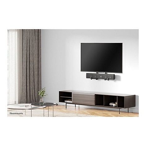 Ein Flachbildfernseher hÃ¤ngt Ã¼ber einer Soundbar und einem Lowboard. Im Hintergrund VorhÃ¤nge und Couchtisch.