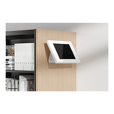 WeiÃŸes Tablet mit schwarzem Bildschirm an Holzverkleidung montiert. Daneben BÃ¼cherregal.