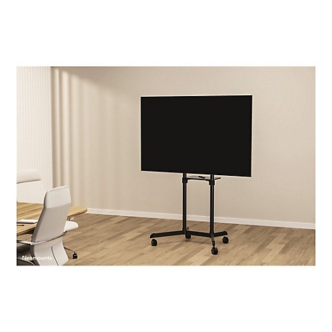 Téléviseur à écran plat noir sur un support noir à roulettes. Aménagement de bureau en arrière-plan.
