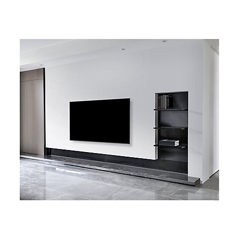 Un espace de vie minimaliste avec une télévision moderne sur un mur blanc. Une étagère avec des livres est encastrée dans le mur.