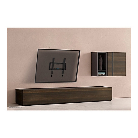 TV-Halterung an Wand, darunter eine niedrige Kommode und ein Schrank mit Dekorationsgegenständen.