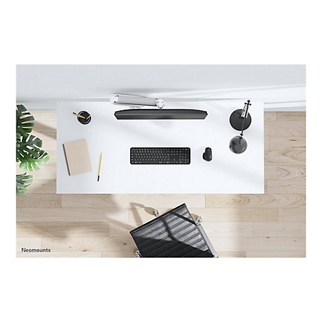 Draufsicht auf einen modernen Schreibtisch: schwarze Tastatur, Maus, Notizblock, Lampe und Stuhl. Holzfußboden.