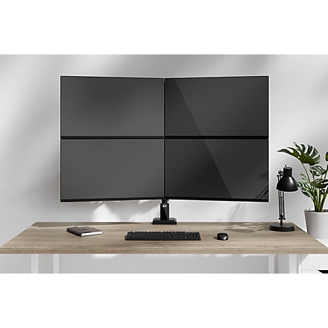 Mehrfachbildschirm-Setup mit vier schwarzen Monitoren über einem Schreibtisch. Auf dem Schreibtisch liegen Tastatur, Maus und Notizbuch.