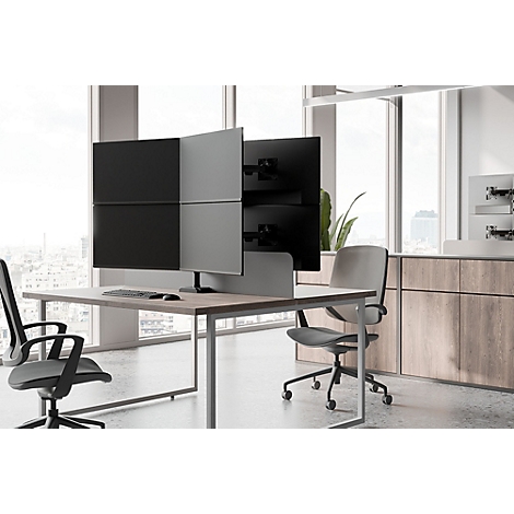 Kantoor met bureau, meerdere schermen en stoelen. De ruimte is licht en modern ingericht.