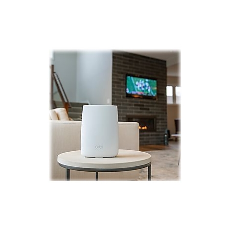 WeiÃŸer Router auf einem runden Tisch in einem Wohnzimmer. Im Hintergrund Fernseher und Kamin.