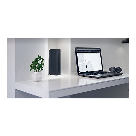 Schreibtisch mit Laptop, KopfhÃ¶rern, Router und Topfpflanze. WeiÃŸer Schreibtisch, grauer Router.