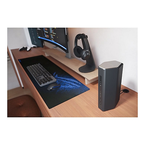 Schreibtisch mit Monitor, Tastatur, Maus, Router und KopfhÃ¶rer. HolzoberflÃ¤che mit blauer Gaming-Mausunterlage.