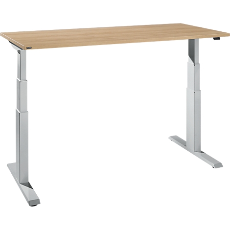 An adjustable desk with a light wood top and silver legs standing against a white background.
