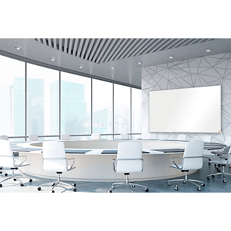 Sala de conferencias moderna con mesa redonda, sillas y una gran pizarra en la pared. Se ven edificios y el cielo afuera.