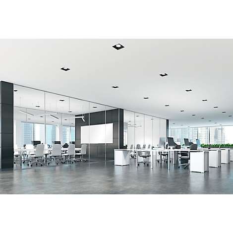 Oficina brillante y moderna con paredes de vidrio, mesas y sillas. Luces de techo y suelo gris.