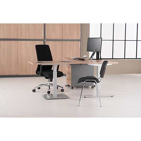 Büro mit Schreibtisch, Stühlen und Computer. Hintergrund: Schrankwand und Fenster.