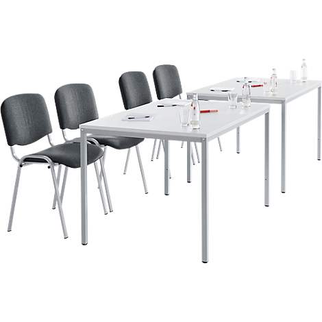 Konferenztische und Stühle, teilweise mit Wasserflaschen und Gläsern.