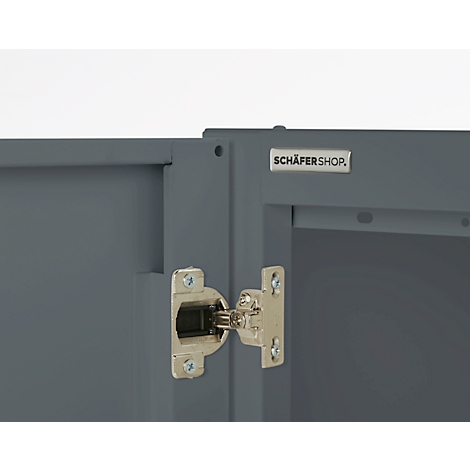 Close-up of a grey cabinet with a silver hinge attachment. The text 'SCHÄFERSHOP' can be seen.
