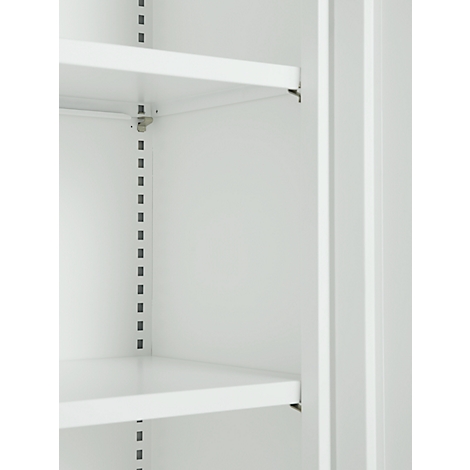 Close-up of an empty, white cabinet with shelves. Vertical rows of holes for shelf supports.