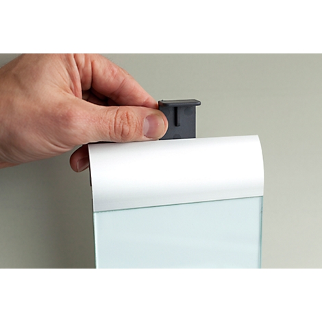 A hand attaches a gray holder to a white case. A glass panel is visible behind it.