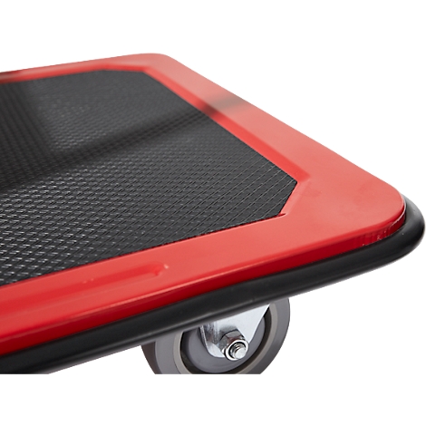 Gros plan d'un diable rouge avec une surface noire texturée et une bordure noire, une roue en bas à droite.