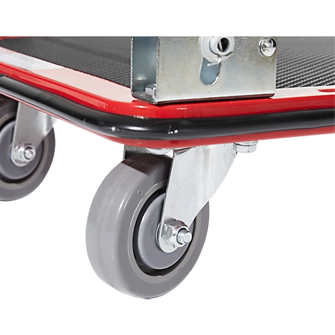Gros plan d'un chariot de transport rouge avec des roues grises. Bordure noire et support argenté.