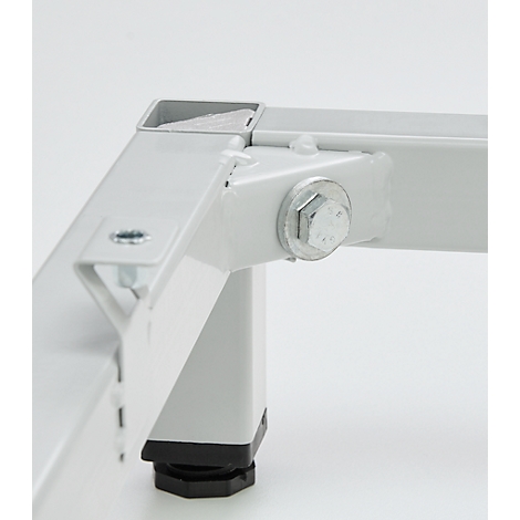 Detailopname van een witte metalen constructie. Schroeven, hoeken en een zwarte voet zijn zichtbaar.