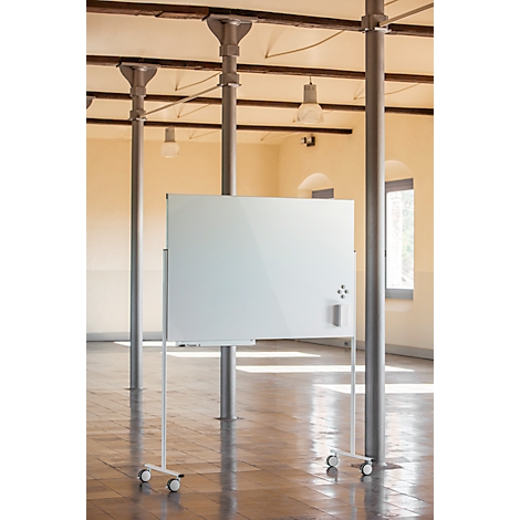 Wit whiteboard op wielen. Kolommen en balken op de achtergrond, in een heldere kamer.