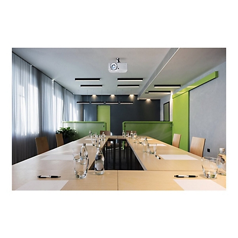 Konferenzraum mit groÃŸem Tisch, StÃ¼hlen, GlÃ¤sern, Flaschen, Stiften und einem Deckenprojektor.