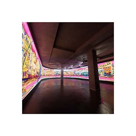 Grande salle avec des murs LED incurvés affichant un paysage urbain. Sol sombre, piliers et poutres au plafond.