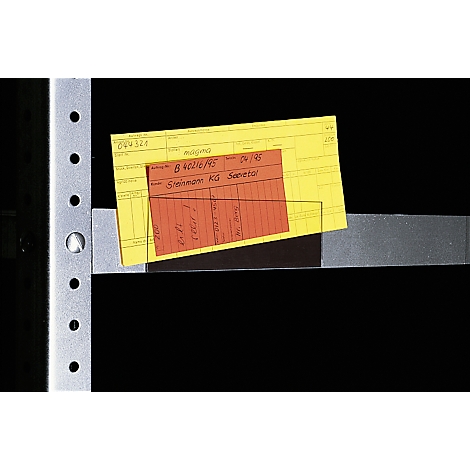 Yellow and red paper with handwritten notes lies on a gray metal construction.
