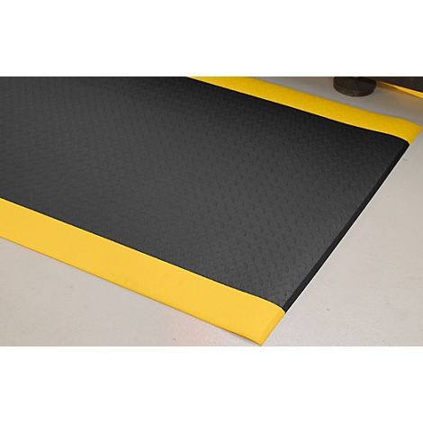 Black mat with yellow edges on a light surface.
