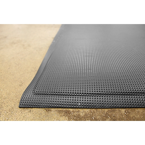 Dark gray rubber mat with a square pattern on light brown floor. The edge is rounded.