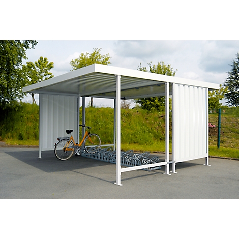 Bike shelter with an orange bike in front. The shelter is white and stands on an asphalt surface.