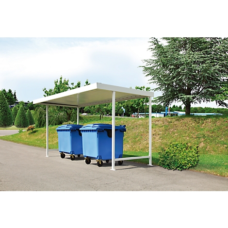 Two blue trash cans stand under a white shelter on a sidewalk. In the background trees and green spaces.