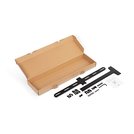 Boîte brune ouverte avec matériel de montage noir pour une TV : rails, supports, vis, clé Allen et instructions.