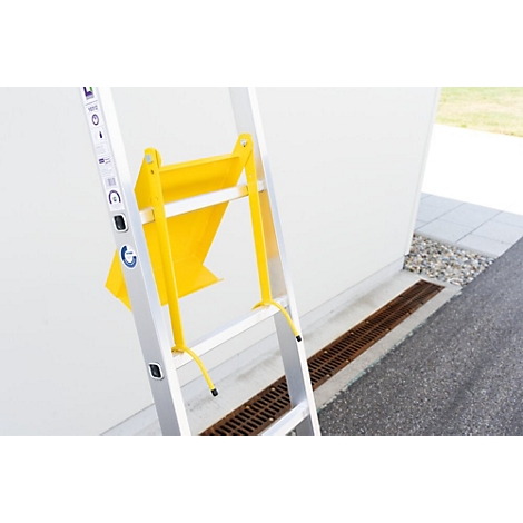 Échelle argentée avec accessoire jaune devant un mur blanc. Plan détaillé.