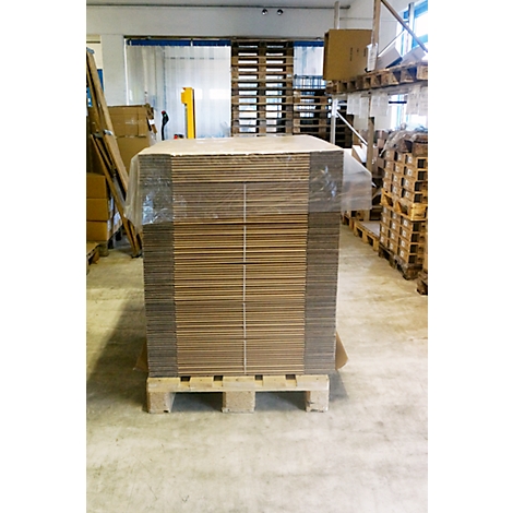 A stack of new, unused cardboard boxes on a pallet in a warehouse.