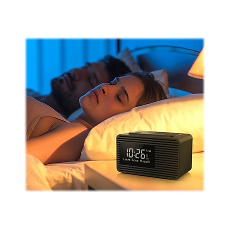 Schlafendes Paar im Bett. Ein Radiowecker auf dem Nachttisch zeigt die Uhrzeit an.