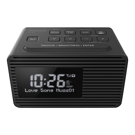 Dunkelgrauer Panasonic-Radiowecker. Uhrzeit 10:26 Uhr mit Radiosenderanzeige. Bedienknöpfe und Display, horizontal gerillt.