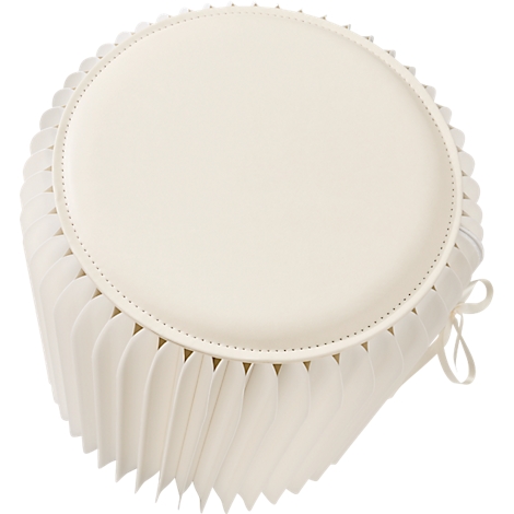 Ronde, witte kruk met gerimpelde rand. Plat bovenop, geplooid eronder, met strik.