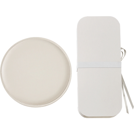Lichtbeige bord met decoratieve rand, naast een witte, rechthoekige doos met een strik.