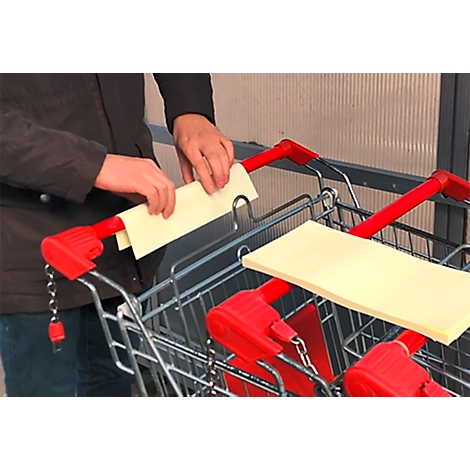 Personne plaçant du papier sur un chariot. Poignées rouges, papier jaune.