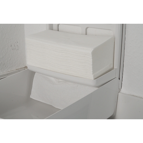 Witte papieren handdoekdispenser met gevouwen handdoeken. Eén handdoek is eruit getrokken.