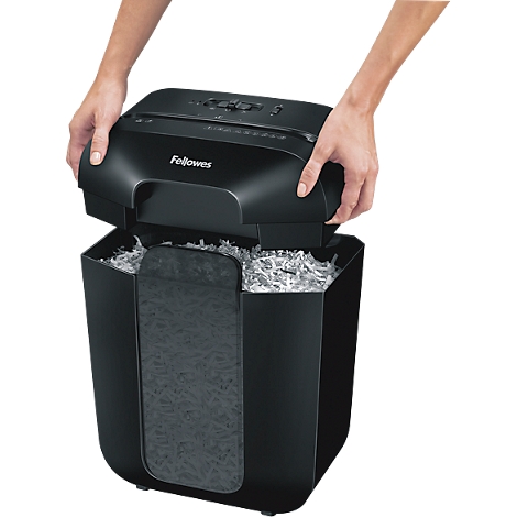 Handen die het zwarte deksel van een Fellowes papierversnipperaar optillen om de bak te legen.