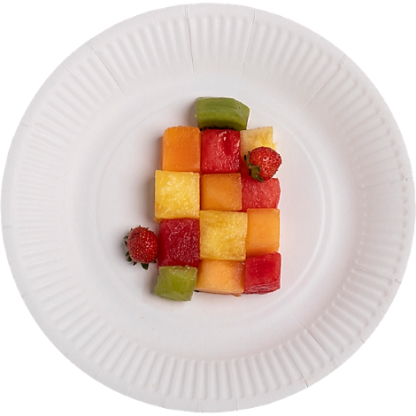 Auf einem weißen Teller befinden sich Würfel aus verschiedenen Früchten, darunter Erdbeeren, Melone, Kiwi und Ananas.