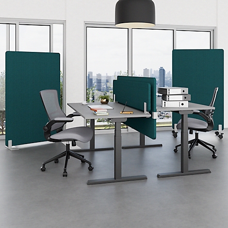 Bureau avec bureaux réglables en hauteur, séparateurs et chaises. Des fenêtres avec vue sur une ville sont visibles en arrière-plan.