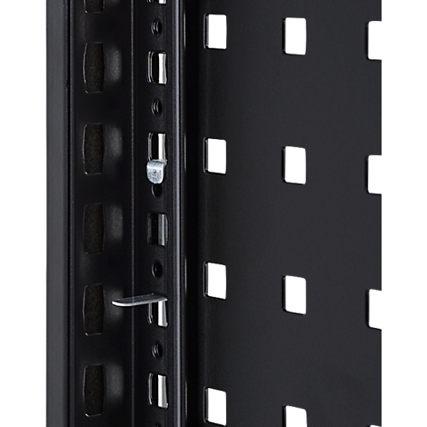 Gros plan sur une construction métallique noire avec des ouvertures rectangulaires et des raccords métalliques.