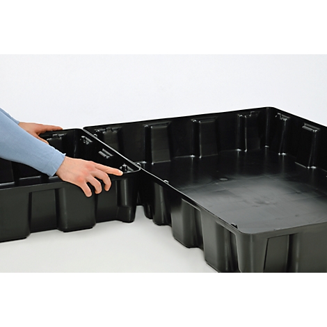 Two hands connecting two black plastic trays. On a white background.