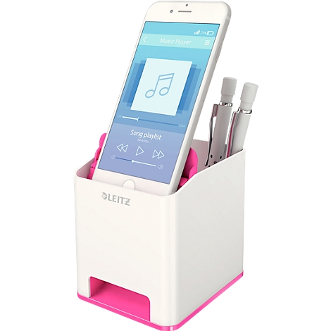 White pen holder with pink accents, phone with music app, two pens.