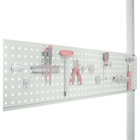 Tool wall with pink tools. Screwdrivers, pliers and wrenches are neatly arranged on the pegboard.