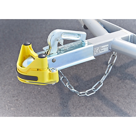 Close-up of a trailer hitch. Yellow housing, silver metal, safety chain.